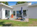 Relaxing outdoor patio area with stylish furniture, a colorful rug, and a peaceful backyard setting at 3090 6Th St, Sarasota, FL 34237