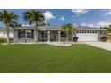 Charming single-Gathering home featuring a lush green lawn and swaying palm trees at 3889 Canopy Way, Sarasota, FL 34235