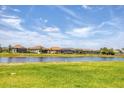 A picturesque waterfront view showcasing a serene pond, verdant greenery, and a row of well-maintained homes at 4750 Tortona Ct, Bradenton, FL 34211