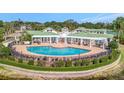 Stunning community pool with ample seating, manicured landscaping, and a pergola covered lounge area at 4802 51St W St # 107, Bradenton, FL 34210