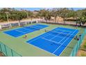 Well-maintained community tennis courts with vibrant blue surfaces surrounded by lush greenery at 4802 51St W St # 107, Bradenton, FL 34210