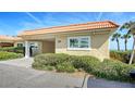 Charming home exterior featuring lush landscaping, a convenient carport, and a durable tile roof at 4968 Gulf Of Mexico Dr # Villa 22, Longboat Key, FL 34228