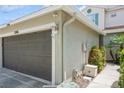Attached garage with a brown garage door, lighting fixture, and well-maintained landscaping at 5346 Neil Dr, St Petersburg, FL 33714