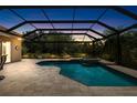 Screened-in pool with a spa is surrounded by a stone deck and lush landscaping at 6231 Cypress Bend Ct, University Park, FL 34201