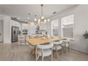Open-concept dining area and kitchen featuring a stylish light fixture and seating for six at 8612 Evening Dr, Sarasota, FL 34241