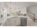 Modern kitchen featuring white cabinetry, quartz countertops, stainless steel appliances, and open sightlines at 8612 Evening Dr, Sarasota, FL 34241