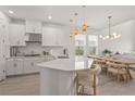Bright, open kitchen with white cabinetry, quartz countertops, stainless steel appliances, and stylish pendant lighting at 8612 Evening Dr, Sarasota, FL 34241