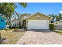 Beautiful single Gathering home featuring a charming exterior with a spacious two-car garage and brick driveway at 1010 Tropical Dr, Bradenton, FL 34208