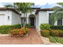 Inviting entryway with brick path and meticulously maintained landscaping at 1034 Buttercup Gln, Bradenton, FL 34212