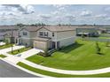Aerial view of a home with a green lawn in a neighborhood with similar-style houses at 10464 Ladybug Cv, Parrish, FL 34219