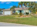 Well-maintained home featuring a stone facade garage, lush lawn, and mature palm trees in desirable area at 1104 76Th Nw St, Bradenton, FL 34209