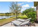 Scenic backyard overlooking a serene pond, complete with lush landscaping and lounge chairs at 11959 Tapestry Ln, Venice, FL 34293