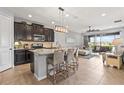 Open-concept kitchen featuring a large island with barstool seating, modern appliances, and tiled flooring at 11959 Tapestry Ln, Venice, FL 34293