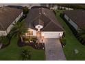 Aerial view of a home with lush landscaping, brick driveway, and a tranquil lake in the background at 17418 Blue Ridge Pl, Lakewood Ranch, FL 34211