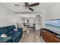 Comfortable living room featuring wood-look flooring, ceiling fan, and lots of natural light at 2008 Canal Dr # M3, Bradenton, FL 34207
