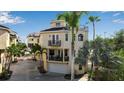 Beige three-story home featuring multiple balconies and a rooftop deck, surrounded by lush palm trees at 436 Canal Rd # A, Sarasota, FL 34242