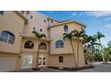 Exterior corner view of a beige three-story home showing the entrance and multiple arched windows at 436 Canal Rd # A, Sarasota, FL 34242