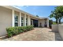 Inviting entrance showcasing a patterned brick paver patio and lush landscaping at 4861 Waterbridge Down, Sarasota, FL 34235