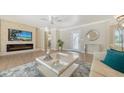 Bright living room featuring a decorative fireplace, modern furniture and a ceiling fan at 4861 Waterbridge Down, Sarasota, FL 34235