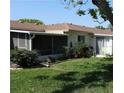 Backyard featuring a screened porch, green lawn, and lush garden at 5057 Live Oak Cir # 86, Bradenton, FL 34207