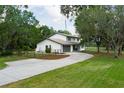 Two-story home exterior showcases a well-manicured lawn, gray roof, and inviting driveway at 5403 Red Rooster Rd, Parrish, FL 34219