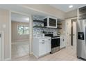 Stylish kitchen boasting floating shelves, stainless steel range, and white cabinetry at 5403 Red Rooster Rd, Parrish, FL 34219