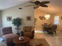 Cozy living room featuring neutral tones, tile floors, comfortable seating, and adjacent dining area at 5712 34Th W Ct, Bradenton, FL 34210