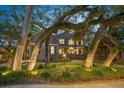 Stately two-story home with dark shutters and mature landscaping, set amongst large, shady trees at 5716 Bayshore Blvd, Tampa, FL 33611