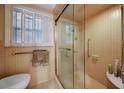 Bathroom with tiled shower with glass doors, tile walls, and a window with shutters at 705 Whitfield Ave, Sarasota, FL 34243