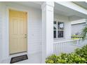 Inviting front porch with a classic yellow door, white trim, and neatly maintained greenery at 7526 Ridgelake Cir, Bradenton, FL 34203