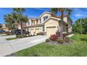 Beautiful multi-story townhome with a private garage, landscaped yard, and tropical palm tree accents at 8352 Enclave Way # 104, Sarasota, FL 34243