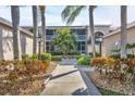 Condo exterior view featuring palm trees, well-maintained landscaping, and screened in porch at 9560 High Gate Dr # 1622, Sarasota, FL 34238