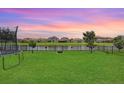 Expansive backyard with lush green grass and tranquil water view, perfect for outdoor activities at 9646 Ivory Dr, Ruskin, FL 33573