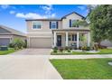 Inviting two-story home with a well-maintained lawn and charming front porch at 9646 Ivory Dr, Ruskin, FL 33573