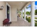 Covered porch with brick pavers, white columns, and cozy seating area at 9646 Ivory Dr, Ruskin, FL 33573