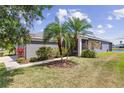 Inviting single-story home featuring palm trees and well-maintained landscaping accenting the grey exterior at 9840 50Th Street E Cir, Parrish, FL 34219