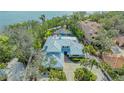 Expansive aerial view of the meticulously maintained property with a screened-in pool and lush tropical landscaping at 1042 N Casey Key Rd, Osprey, FL 34229