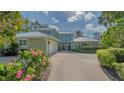 Charming two-story home featuring a lush landscaped front yard, a two-car garage, and a cozy covered porch at 1042 N Casey Key Rd, Osprey, FL 34229