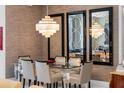Modern dining room features glass table with seating for six and statement chandelier, with reflective mirrors on the wall at 111 S Pineapple Ave # 716, Sarasota, FL 34236