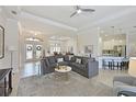 Bright living room with a large sectional sofa, neutral tones, and an open layout to dining and kitchen at 12811 Penguin Dr, Bradenton, FL 34212