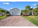 Inviting single-story home features a brick paved driveway, lush landscaping, and a two-car garage at 14444 59Th E Cir, Bradenton, FL 34211