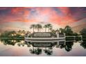 Lakewood National entrance with serene lake and a dramatic sunset sky backdrop, reflecting in the water at 17510 Gawthrop Dr # 206, Bradenton, FL 34211