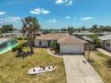 An aerial view shows a well-kept property with landscaping and an extended driveway, surrounded by a residential neighborhood at 1789 Elm Dr, Venice, FL 34293