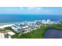 Stunning aerial view of beachfront condos with access to pristine white sand and blue ocean waters at 2100 Benjamin Franklin Dr # 201, Sarasota, FL 34236