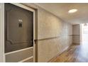 Hallway with apartment doors, neutral wall color, wood-look floors, and recessed lighting at 2100 Benjamin Franklin Dr # 201, Sarasota, FL 34236