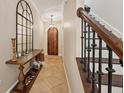 Inviting foyer with arched wood door, elegant mirror and wood staircase at 2221 Bahia Vista St, Sarasota, FL 34239