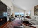 Spacious living room boasting a fireplace, high ceilings, hardwood floors, and expansive windows overlooking the water at 2282 Harbour Court Dr, Longboat Key, FL 34228