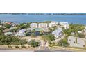 Breathtaking aerial view of a luxury residential complex with a pool, tennis courts, and bay access at 242 Hidden Bay Dr # 603, Osprey, FL 34229