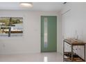 Bright entryway featuring a unique door with a vertical window and modern finishes at 2560 Sunnyside St, Sarasota, FL 34239