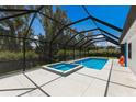 Enclosed screened pool with a spa and lush landscaping creating a private and relaxing backyard retreat at 2560 Sunnyside St, Sarasota, FL 34239